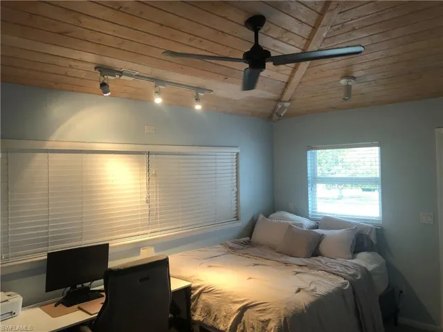 Bedroom with wood ceiling, track lighting, a desk, vaulted ceiling, and ceiling fan