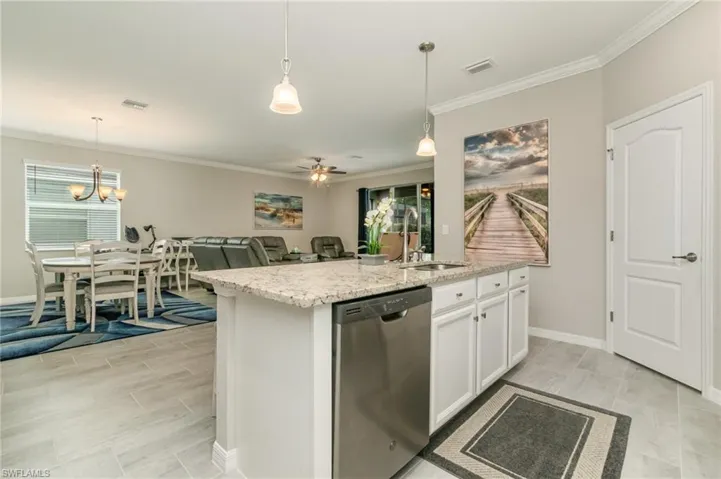 Kitchen with crown molding, a sink, dishwasher, open floor plan, and visible vents