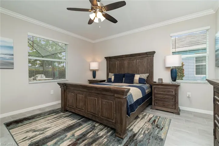Bedroom featuring baseboards, ornamental molding, and a ceiling fan