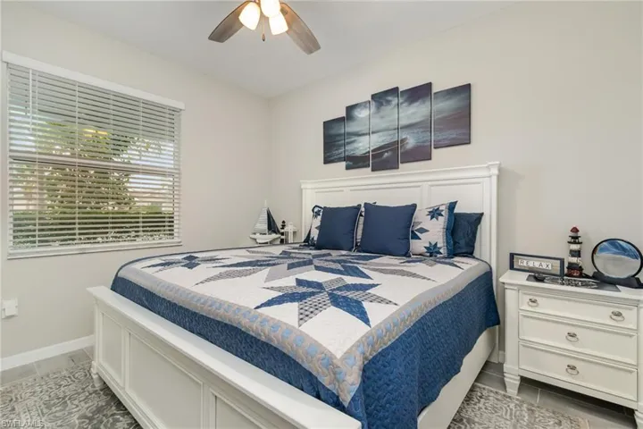 Bedroom with baseboards, tile patterned flooring, and a ceiling fan