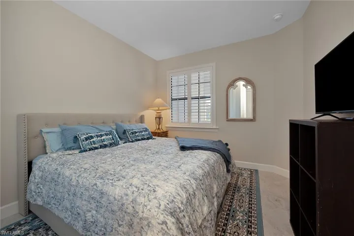 Bedroom featuring baseboards and vaulted ceiling