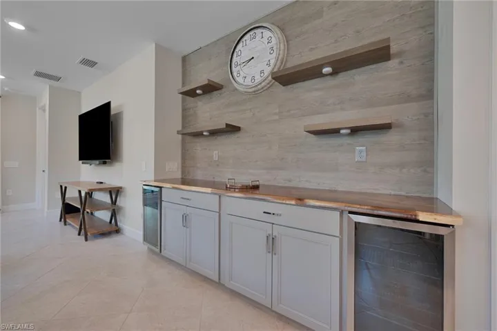 Bar area featuring open shelves, beverage coolers, butcher block counters, and recessed lighting