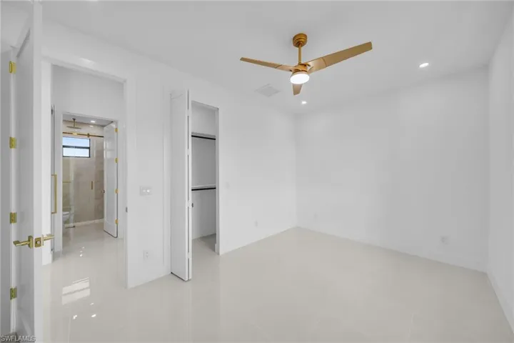 Unfurnished bedroom featuring a spacious closet, recessed lighting, and ceiling fan