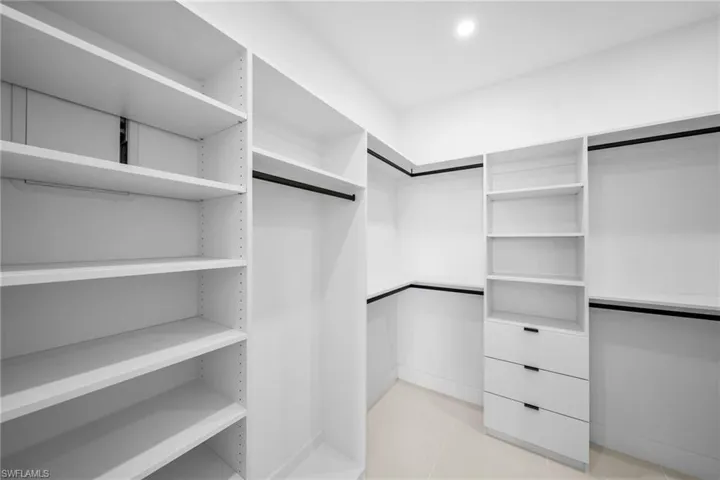 Walk in closet with light tile patterned floors