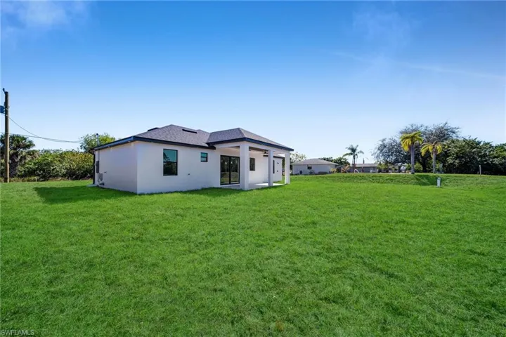 Back of house with a lawn, stucco siding, a patio, and ceiling fan