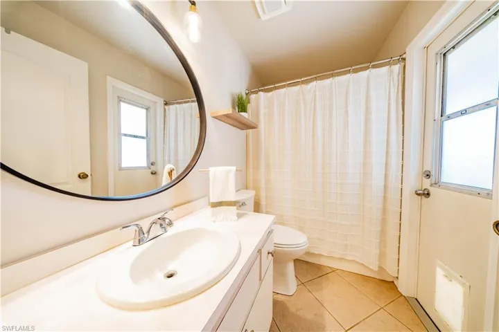 Bathroom with vanity, a shower with curtain, and light tile patterned flooring