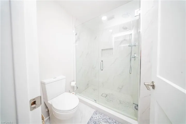 Bathroom with toilet and a marble finish shower