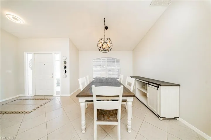 Dining space featuring light tile patterned floors and hanging lights