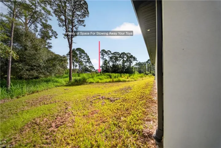 Expansive grassy area with natural landscaping and mature trees
