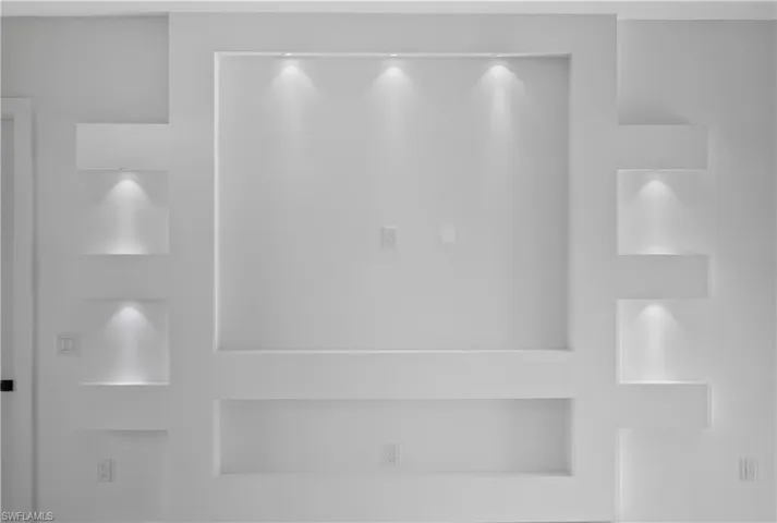 Custom built-in wall unit with integrated display niches, recessed lighting, and a central media area
