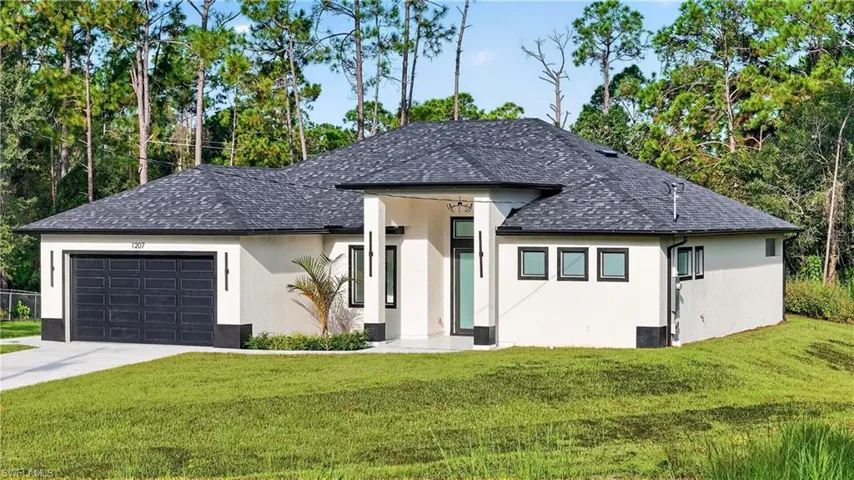 White stucco exterior with a dark shingle roof
