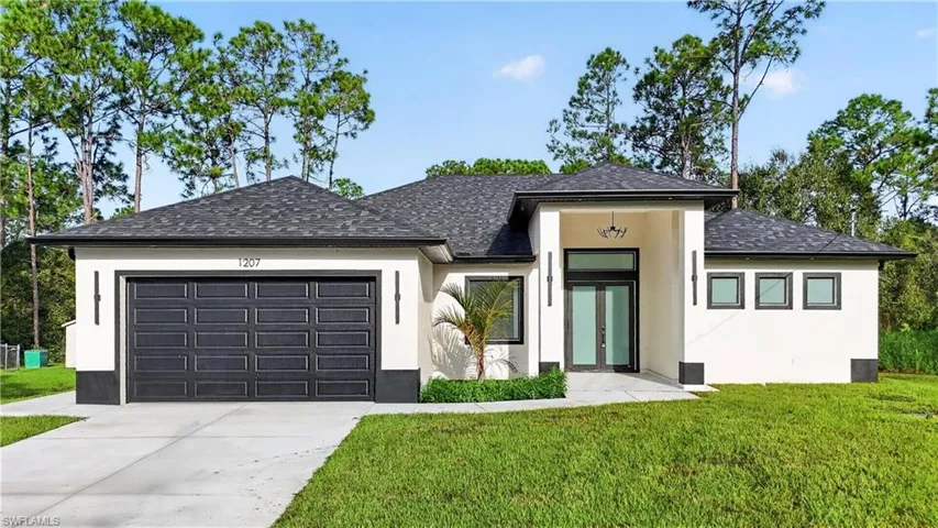 Stucco exterior with a dark shingle roof, attached two-car garage, and a covered entryway with double doors