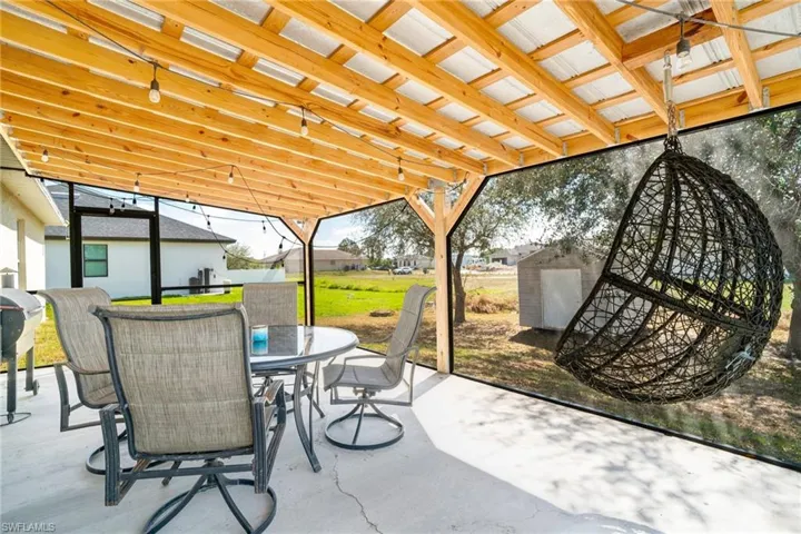 View of patio / terrace featuring a storage unit, outdoor dining space, and an outbuilding