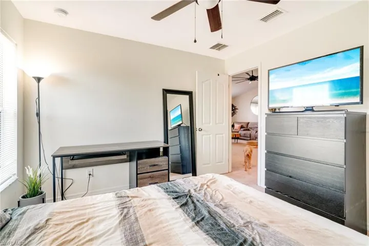 Carpeted bedroom featuring visible vents and a ceiling fan