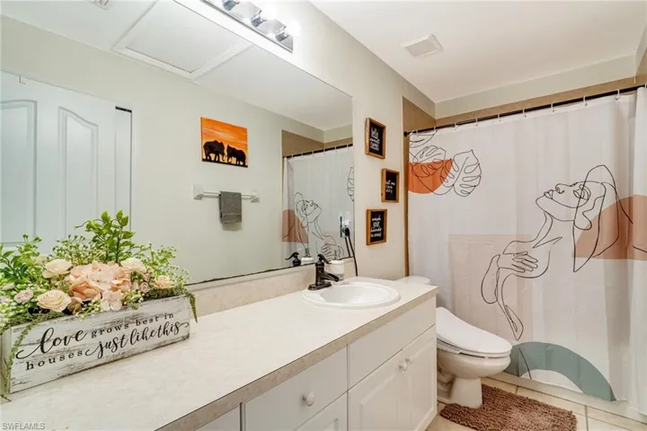 Full bathroom with tile patterned flooring, visible vents, vanity, and toilet