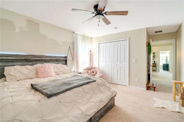 Bedroom with carpet floors, a closet, visible vents, ceiling fan, and baseboards