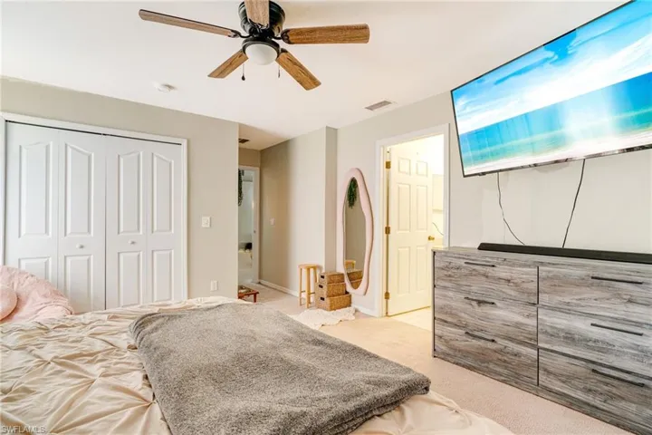 Carpeted bedroom featuring a closet, visible vents, and ceiling fan