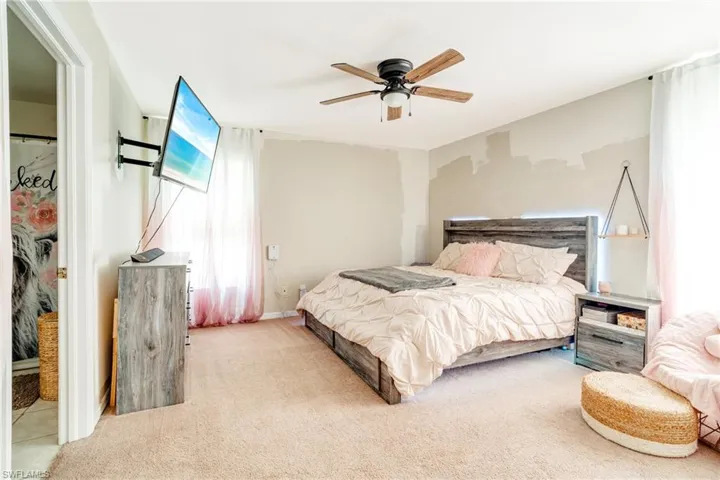 Carpeted bedroom featuring ceiling fan