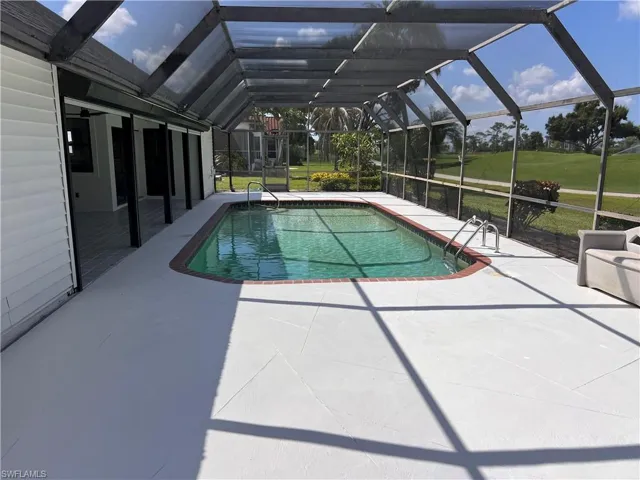 View of swimming pool with a lanai, a patio, and a yard