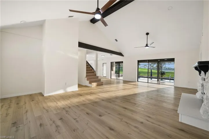 Unfurnished living room featuring high vaulted ceiling, ceiling fan, and hardwood / wood-style flooring