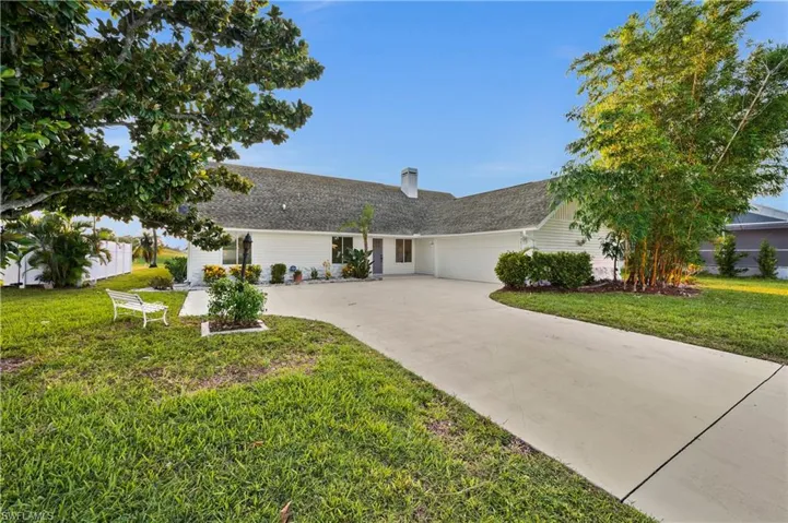 Single story home featuring a garage and a front lawn