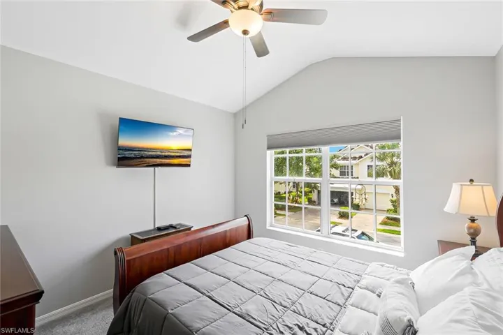 Bedroom with carpet flooring, ceiling fan, and lofted ceiling