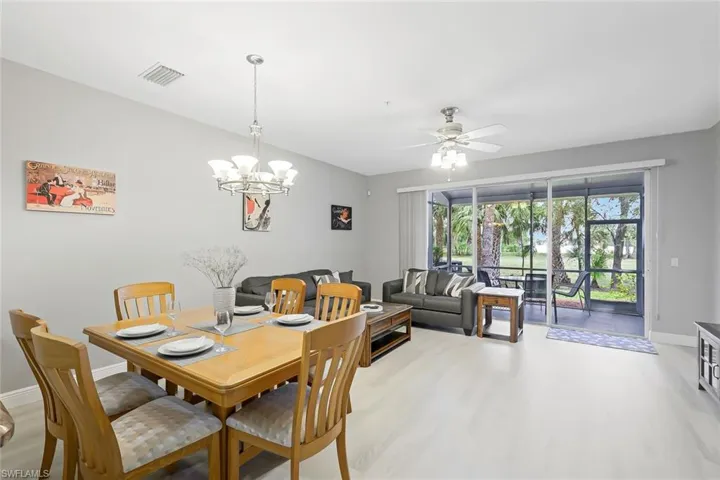 Dining space featuring ceiling fan with notable chandelier and light hardwood / wood-style flooring