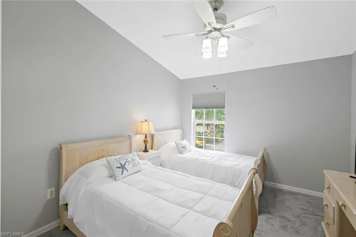 Bedroom with carpet, ceiling fan, and vaulted ceiling