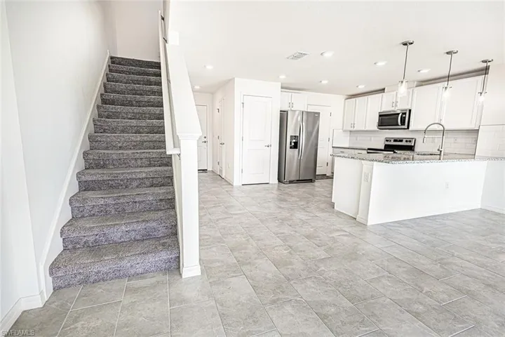 Kitchen featuring visible vents, white cabinets, appliances with stainless steel finishes, recessed lighting, and light stone counters
