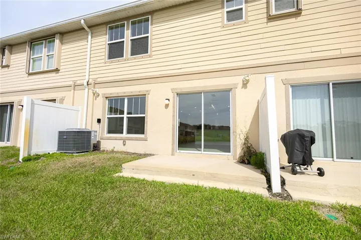 Back of property featuring a patio, central air condition unit, fence, and a lawn