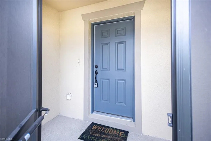 Doorway to property featuring stucco siding