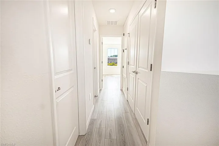 Hall featuring visible vents, recessed lighting, and light wood-style floors