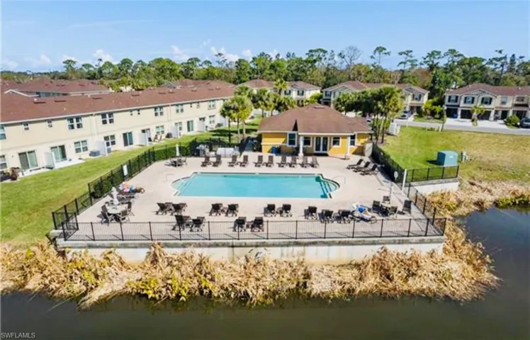 Pool with a yard, fence, a water view, and a patio