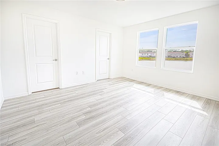 Empty room with baseboards and light wood-type flooring