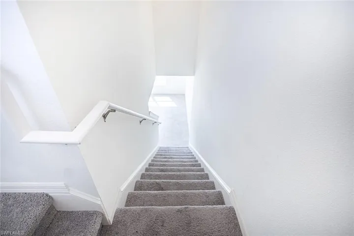 Stairs featuring baseboards and carpet floors