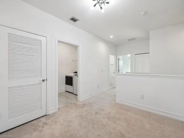 Spare room featuring light colored carpet and washer and clothes dryer
