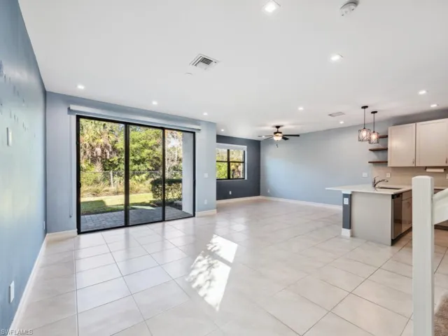 Unfurnished living room with sink, ceiling fan, and light tile patterned flooring