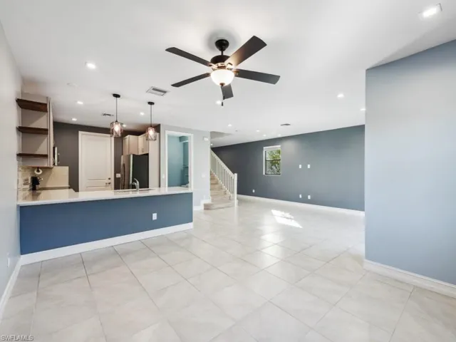 Unfurnished living room featuring ceiling fan and sink