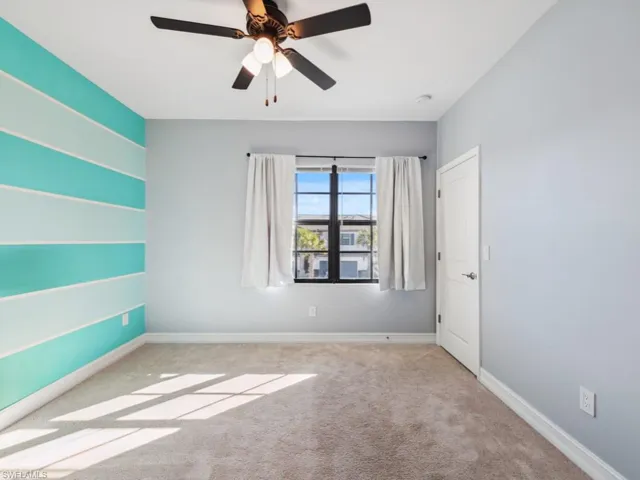 Unfurnished room featuring ceiling fan and light colored carpet