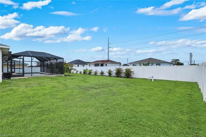 Fenced backyard featuring a lanai, a sunroom, and a pool