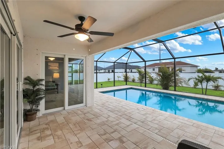 Swimming pool featuring a sunroom, a patio, and glass enclosure