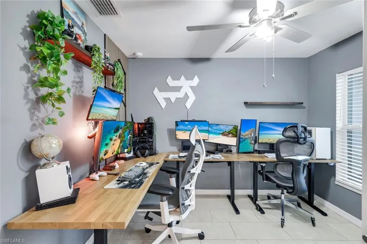 Home office with a ceiling fan and light tile patterned floors