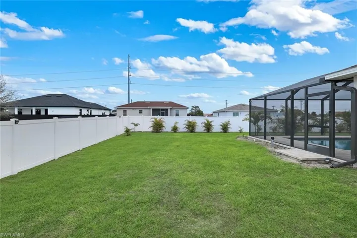 Fenced backyard featuring grass enclosure, a sunroom, and an outdoor pool