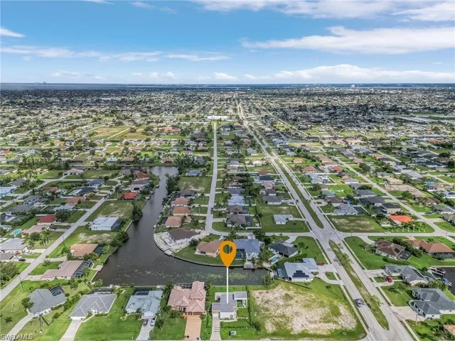 Aerial overview of property's location featuring a nearby body of water and nearby suburban area