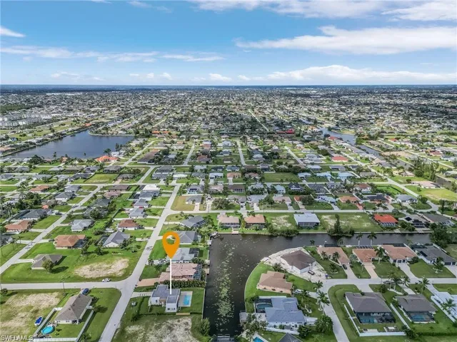 Aerial view of property's location with a nearby body of water and nearby suburban area