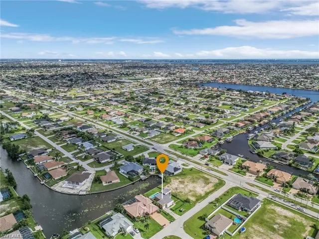 Aerial view of property's location featuring a large body of water and nearby suburban area
