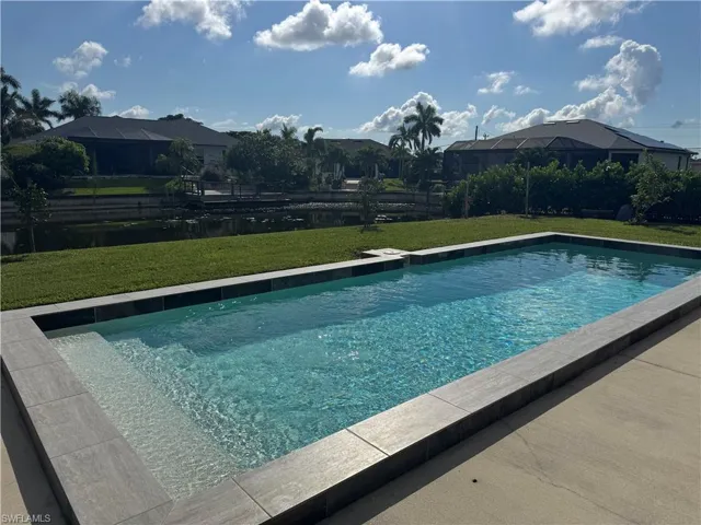Swimming pool with a lawn and a sunroom