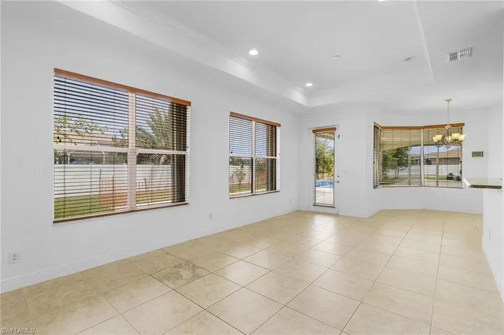 Family room with a tray ceiling, crown molding, and light tile patterned floors