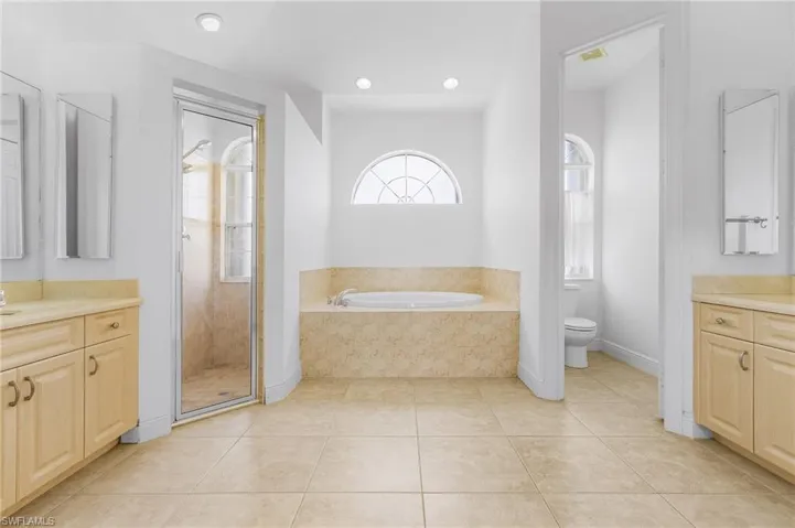 Full bathroom with vanity, tile patterned flooring, toilet, and separate shower and tub