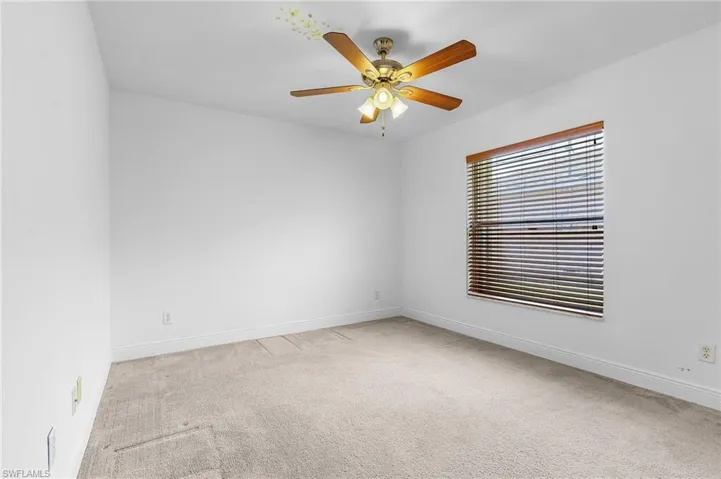Carpeted spare room with ceiling fan
